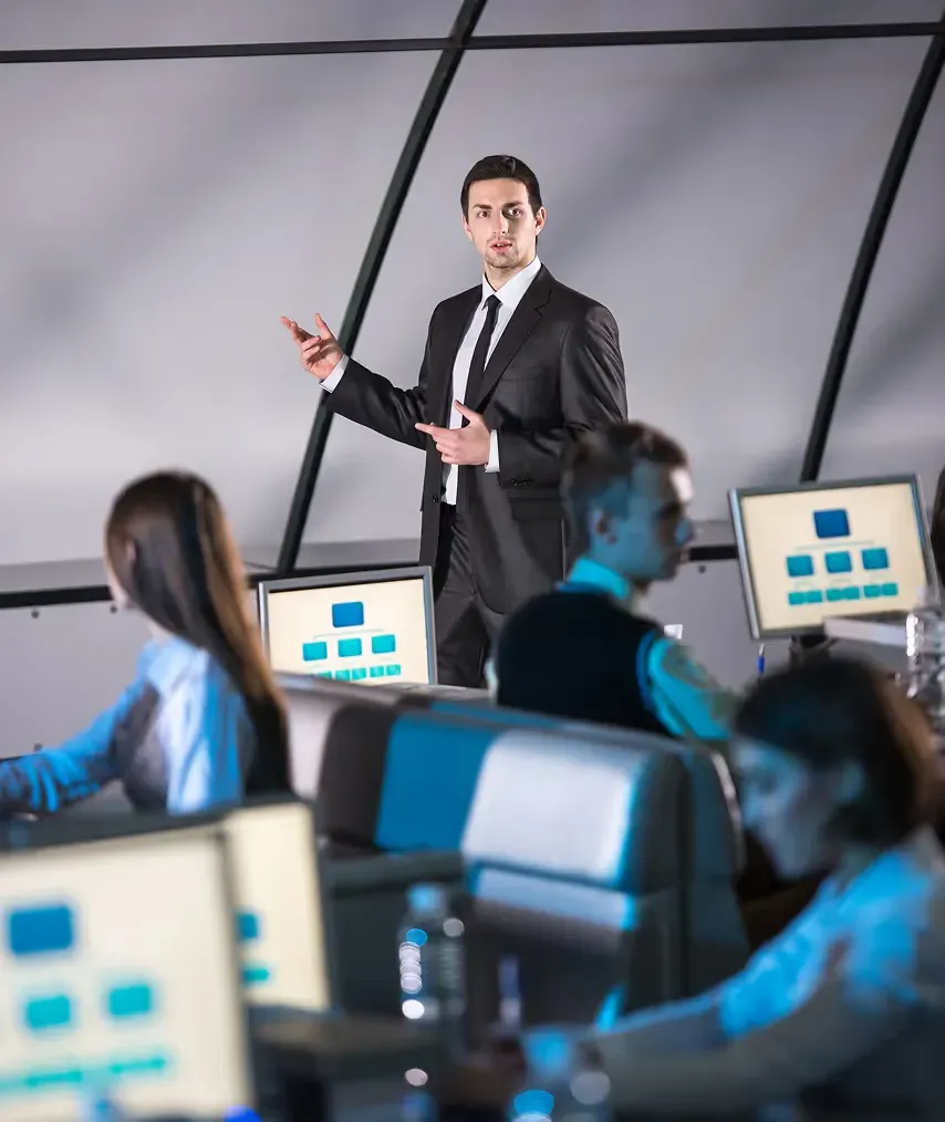 A presenter leading a session in a room of workstations